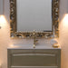 particolare del mobile da bagno classico Dorian, elegante e raffinato, in finitura dorata con ante a telaio, lavabo in ceramica bianca lucida e specchio intarsiato in finitura dorata