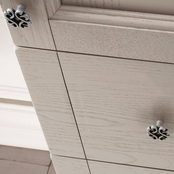 dettaglio delle ante lavorate e dei pomoli in finitura argento antico della composizione mobile da bagno classico sospesa della serie Dorian