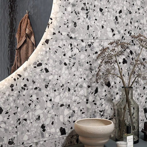 Dettaglio piastrella in gres porcellanato effetto graniglia e marmetta. Collezione Venexia di Alfalux, colore Tronchetto Grigio con marmette grigie, bianche e nere