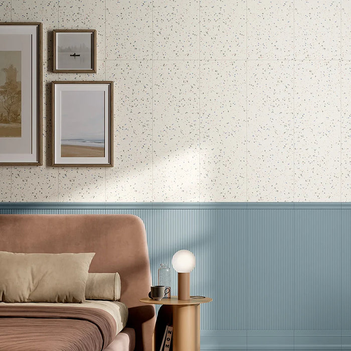 Camera da letto elegante con rivestimento in gres porcellanato effetto graniglia della collezione Brio di Ceramica Rondine, formato 33,3x100 cm, colore Confetti