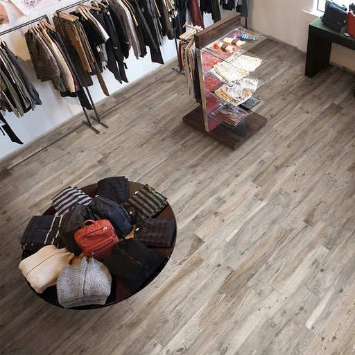 Negozio d'abbigliamento con pavimento in gres porcellanato effetto legno rovere della collezione Hard & Soft di Ceramica Rondine, formato 15x100 cm, colore Soft Greige