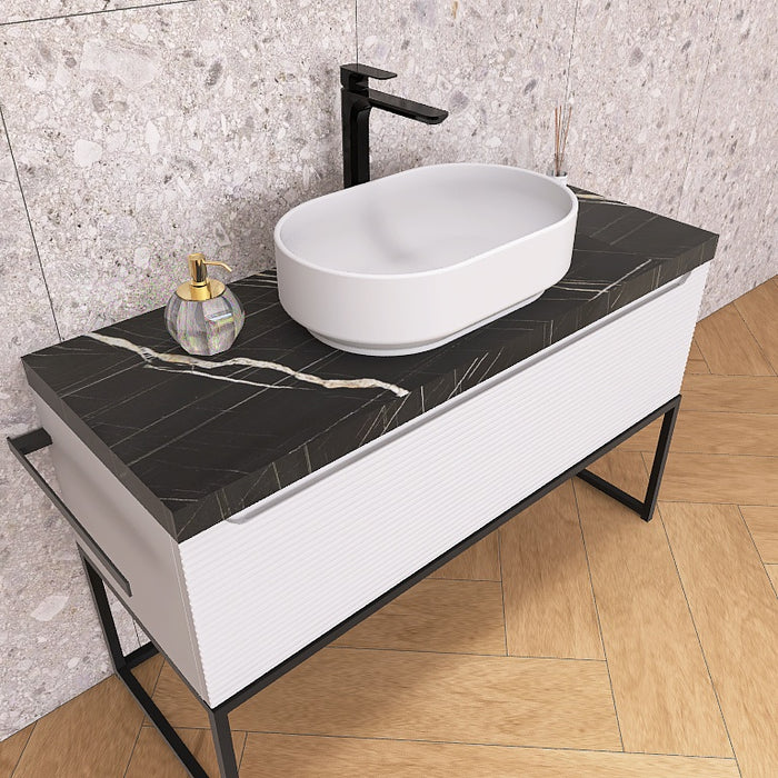 Un moderno mobile da bagno a terra, solido e di grande impatto visivo, grazie alla particolare cornice in metallo nero opaco, che crea un gioco di colore con la base cannettata orizzontale che contraddistingue la serie Penelope.
Altro filo conduttore della serie è il top scatolare nella particolare finitura marmo Nero marquinia.
Penelope 06 è un mobile audace e duraturo, che gioca con colori e materiali, al contempo elegante ed estremamente moderno.
Disponibile nelle finiture: Tortora Opaco, Bianco 