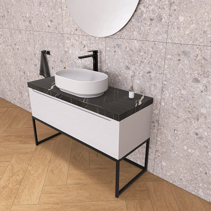 Un moderno mobile da bagno a terra, solido e di grande impatto visivo, grazie alla particolare cornice in metallo nero opaco, che crea un gioco di colore con la base cannettata orizzontale che contraddistingue la serie Penelope.
Altro filo conduttore della serie è il top scatolare nella particolare finitura marmo Nero marquinia.
Penelope 06 è un mobile audace e duraturo, che gioca con colori e materiali, al contempo elegante ed estremamente moderno.
Disponibile nelle finiture: Tortora Opaco, Bianco 