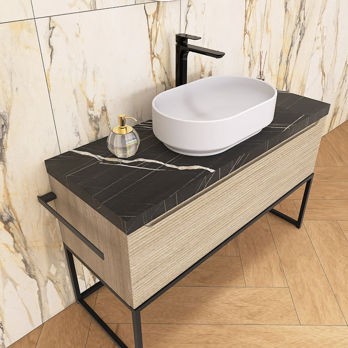 Un moderno mobile da bagno a terra, solido e di grande impatto visivo, grazie alla particolare cornice in metallo nero opaco, che crea un gioco di colore con la base cannettata orizzontale che contraddistingue la serie Penelope.
Altro filo conduttore della serie è il top scatolare nella particolare finitura marmo Nero marquinia.
Penelope 06 è un mobile audace e duraturo, che gioca con colori e materiali, al contempo elegante ed estremamente moderno.
Disponibile nelle finiture: Tortora Opaco, Bianco 