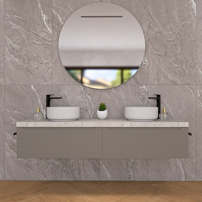 Penelope 07 è un raffinato mobile bagno sospeso con doppio lavabo, top scatolare in finitura marmo calacatta e base con due cassettoni in finitura cannettata orizzontale. Perfetto per bagni moderni e minimalisti, offre un design elegante e funzionale con ampio spazio contenitivo. La composizione include un moderno e armonico specchio rotondo con illuminazione a LED