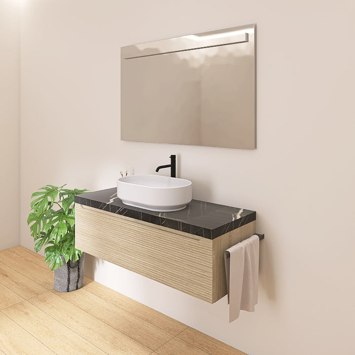 Il mobile presenta un elegante lavabo da appoggio, posizionato su un raffinato top scatolare in marmo nero marquinia. L'ampio cassetto sottostante, lungo ben 120 cm, con le sue discrete scanalature orizzontali e l’ anta a gola tipiche della serie Penelope, offre un pratico spazio contenitivo per riporre asciugamani, cosmetici e altri accessori, mantenendo tutto a portata di mano.
Completa la composizione un ampio specchio rettangolare con l’ elegante illuminazione a LED.