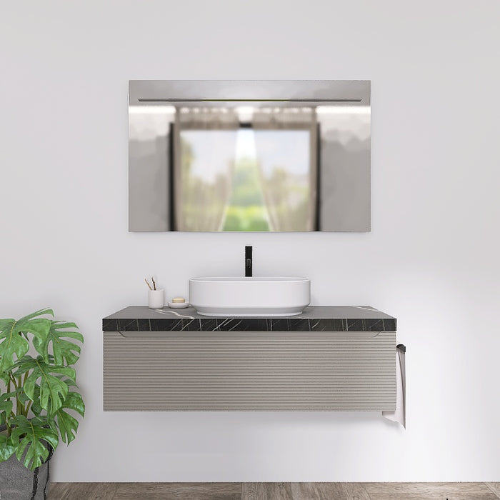 Il mobile presenta un elegante lavabo da appoggio, posizionato su un raffinato top scatolare in marmo nero marquinia. L'ampio cassetto sottostante, lungo ben 120 cm, con le sue discrete scanalature orizzontali e l’ anta a gola tipiche della serie Penelope, offre un pratico spazio contenitivo per riporre asciugamani, cosmetici e altri accessori, mantenendo tutto a portata di mano.
Completa la composizione un ampio specchio rettangolare con l’ elegante illuminazione a LED.
