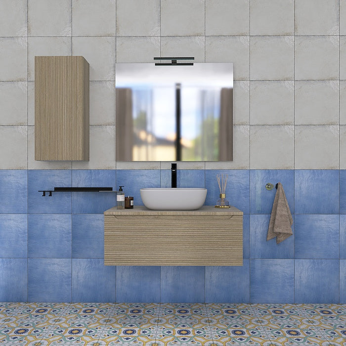 Composizione bagno sospesa interamente realizzata in Italia composta da una base con 1 cassettone in finitura cannettata orizzontale, un top in tinta con la base, un elegante lavabo da appoggio in ceramica bianca, un grande specchio rettangolare a filo lucido con lampada a led, una mensola nera in metallo e un portasciugamani posizionato sul fianco del mobile.

Disponibile nelle finiture: Tortora Opaco, Bianco Opaco, Noce e Rovere.