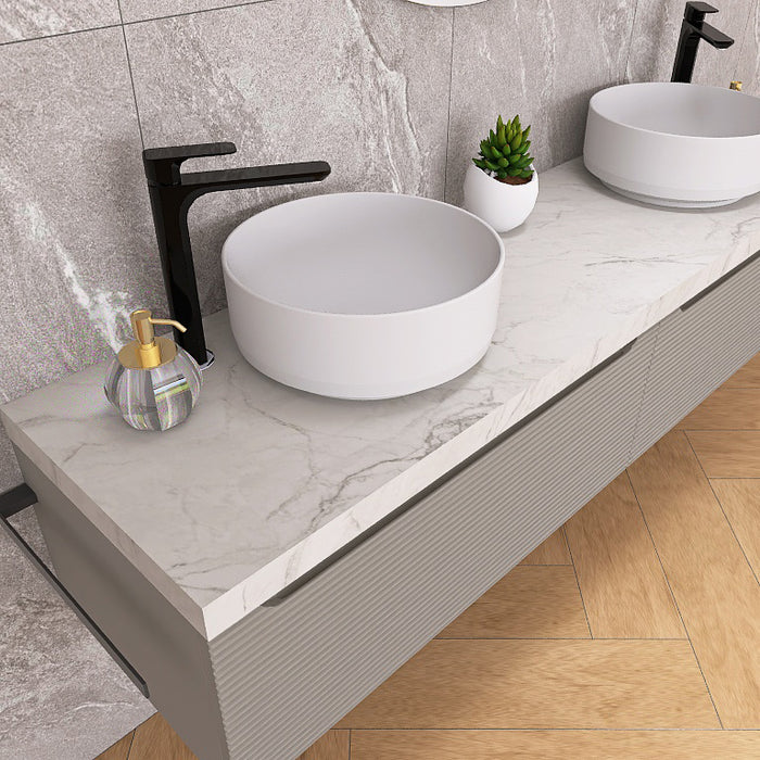 Penelope 07 è un raffinato mobile bagno sospeso con doppio lavabo, top scatolare in finitura marmo calacatta e base con due cassettoni in finitura cannettata orizzontale. Perfetto per bagni moderni e minimalisti, offre un design elegante e funzionale con ampio spazio contenitivo. La composizione include un moderno e armonico specchio rotondo con illuminazione a LED