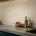 Dettaglio cucina con rivestimento ArkiStone Vanilla Strutturato di Idea Ceramica in gres porcellanato effetto pietra rigata 60x120 cm 