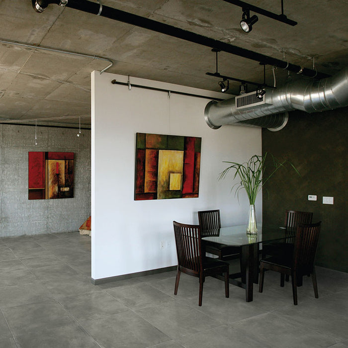 Monolocale in stile moderno undeground con pavimento in gres porcellanato smaltato opaco effetto cemento nuvolato dai toni caldi della collezione Baya di Paul & Co Ceramiche, formato 60x60, colore Black