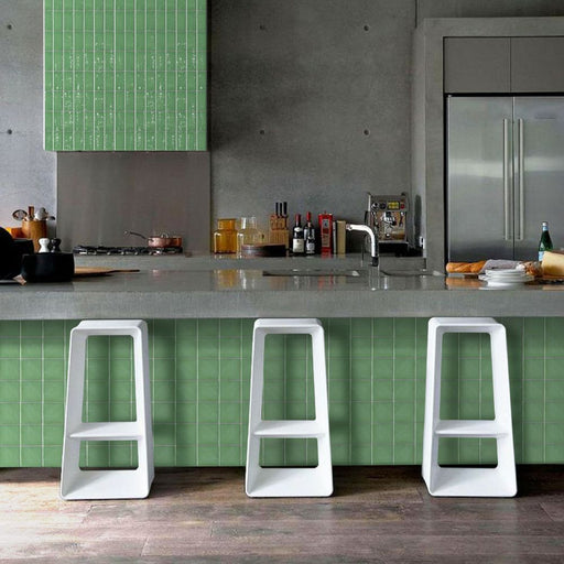 Cucina in stile moderno underground con penisola e sgabelli bianchi e rivestimento verde chiaro Crayon nella colorazione Spring Green Matt di Self Style by Keradom.