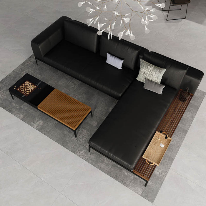 Sala con divano moderno con penisola in pelle nero e  pavimento e rivestimento in gres porcellanato smaltato opaco effetto pietra naturale ardesia della collezione Ecoslate di Paul & Co Ceramiche, formato 60x120, colore White