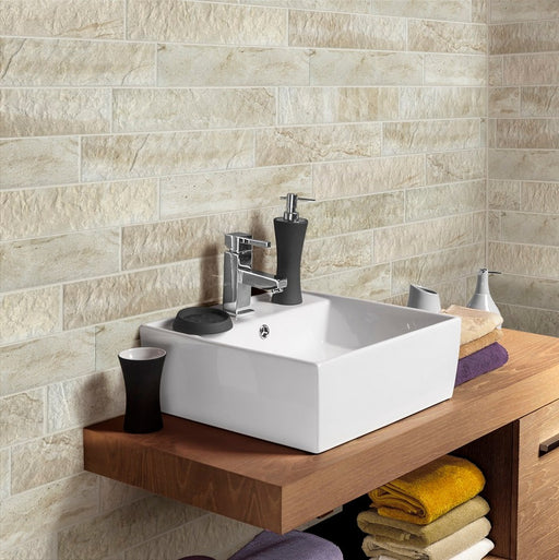 Bagno con piccolo lavabo quadrato bianco  e muro con rivestimento ceramico effetto pietra in formato mattoncino della collezione minerali nella colorazione cromo di keradom