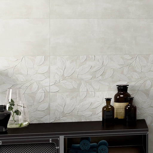 Dettaglio muro con rivestimento effetto cemento con decoro floreale tono su tono leggermente in rilievo della collezione More Plus di Paul & Co Ceramiche, formato 25x75 rettificato, colore Springtime Ice