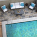 spazio esterno con tavolino, divano e poltrone, piscina interrata e pavimento in gres porcellanato effetto pietra naturale esotica. Collezione Polinesia di Idea Ceramica, Colore Padang Formato 30x60 antiscivolo R11 per esterni