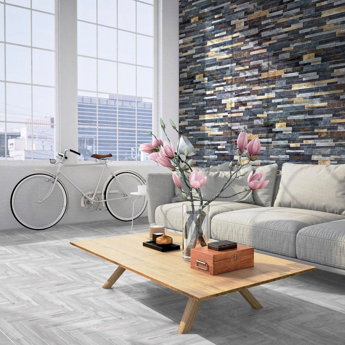 Sala moderna con tavolo basso in legno e divano grigio, muro rivestito con gres porcellanato ad incastro effetto pietra 16x40 della collezione Quarzo nella colorazione Iron di Keradom