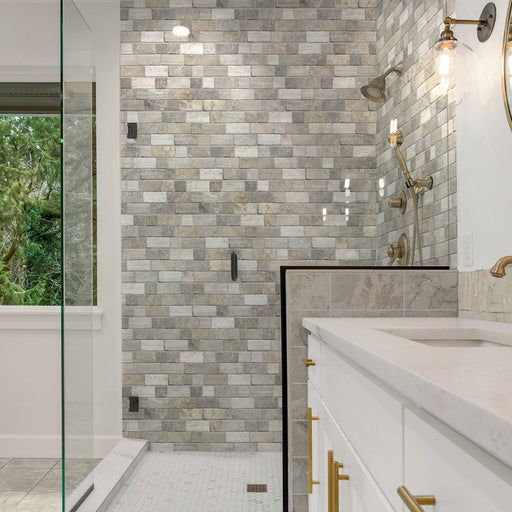 Bagno con doccia quadrata spaziosa, mobile bianco con maniglie oro e rivestimento in gres porcellanato a incastro della collezione Roma nella colorazione Beige di Keradom