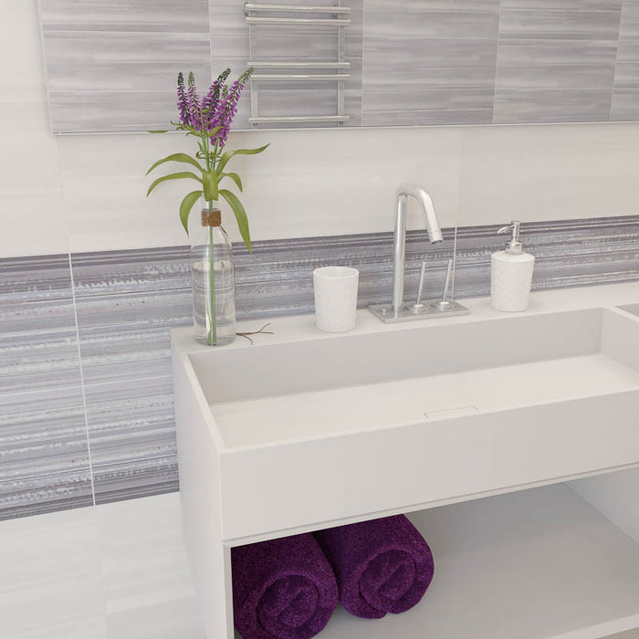 Bagno con mobile sospeso bianco e muro con rivestimento effetto rigato orizzontale lucido della collezione Studio di Paul & Co Ceramiche, formato 25x75, colore Arte Grigio