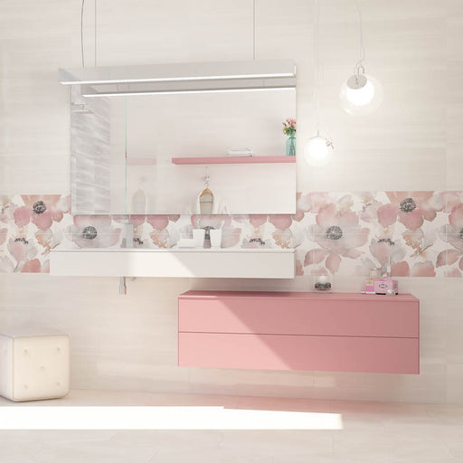 Bagno bianco e rosa con mobile sospeso rosa e mensola portalavabo bianca, muro con rivestimento effetto carta da parati con decoro floreale lucido della collezione Studio di Paul & Co Ceramiche, formato 25x75, colore Petali Grigio