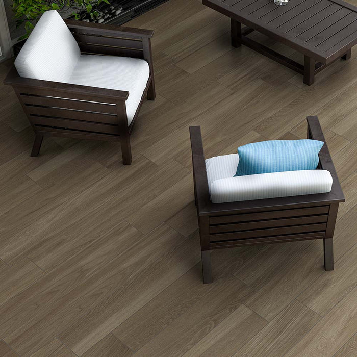 Esterno con poltrone e pavimento in gres porcellanato r11 per esterni della collezione tender di idea ceramica nella colorazione Mogano nel formato 20x120