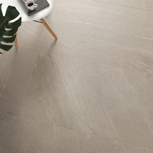 Dettaglio soggiorno con sedia bianca e pianta, pavimento in gres porcellanato smaltato effetto pietra piasentina della collezione Trex di Paul & Co Ceramiche, formato 60x120 rettificato, colore Sand