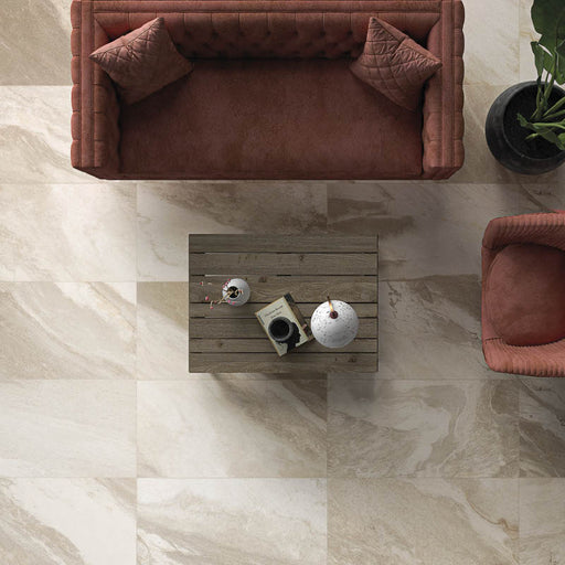 Soggiorno con poltrona e divano color rosso argilla in tessuto, tavolino in legno e pavimento in gres porcellanato effetto pietra moderna della collezione Waves di Savoia Italia Ceramiche, formato 60x120, colore Sand