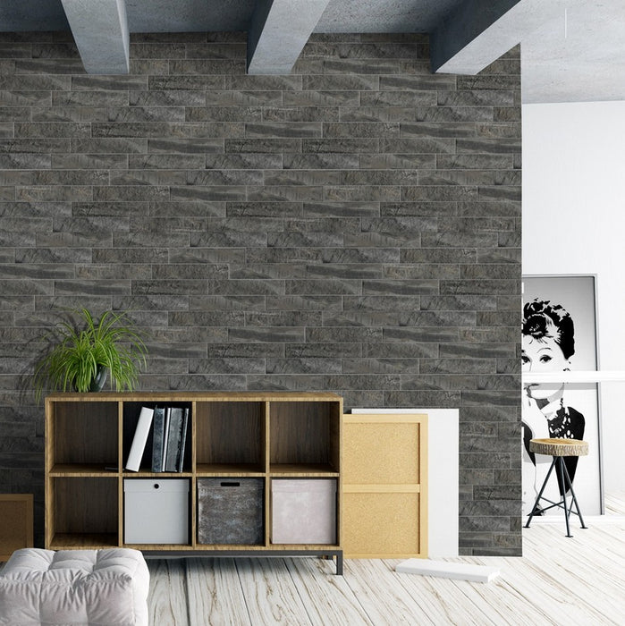 Salotto con scaffale moderno in legno e muro con rivestimento in gres porcellanato effetto mattoncino e pietra della collezione minerali nella colorazione grafite di keradom