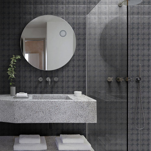 Bagno moderno con lavabo in simil granito, doccia walk in vetro e rivestimento in gres porcellanato smaltato semilucido decorato in stile etnico della collezione origini nella colorazione carbon gombo di self style by keradom