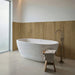 Bagno minimal con vasca in marmo e rivestimento Barrique Heavy di Idea Ceramica in gres porcellanato effetto legno rustico 60x120 cm per pavimenti e rivestimenti senza tempo
