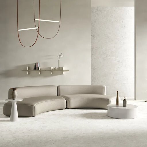 Ambientazione di un soggiorno con colori neutri e con piastrelle in gres porcellanato effetto pietra naturale e vissuta, collezione Blendstone di Settecento Ceramica, colore White 60x120
