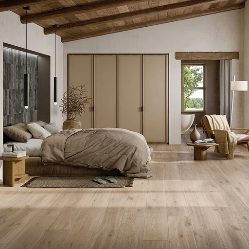 Camera da letto moderna rustica con travi in legno e pavimento in gres porcellanato effetto legno rustico della collezione Cortina di Ceramica Rondine, formato 24x150 cm, colore Beige