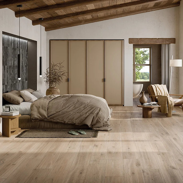 Camera da letto moderna rustica con travi in legno e pavimento in gres porcellanato effetto legno rustico della collezione Cortina di Ceramica Rondine, formato 24x150 cm, colore Beige