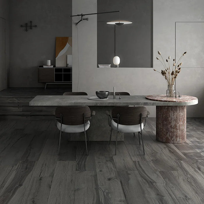 Soggiorno moderno con tavolo in pietra e pavimento in gres porcellanato effetto legno naturale dal carattere rustico della collezione Daring di Ceramica Rondine, formato 24x120 cm, colore Dark