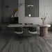 Soggiorno moderno con tavolo in pietra e pavimento in gres porcellanato effetto legno naturale dal carattere rustico della collezione Daring di Ceramica Rondine, formato 24x120 cm, colore Dark
