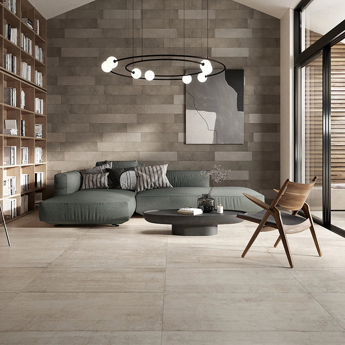 Salotto moderno con divano verde e pavimento in gres porcellanato effetto cemento industriale della collezione Docks di Ceramica Rondine, formato 60x120 cm, colore Beige