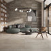 Salotto moderno con divano verde e pavimento in gres porcellanato effetto cemento industriale della collezione Docks di Ceramica Rondine, formato 60x120 cm, colore Beige