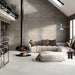 Salotto moderno con divano bianco e rivestimento in gres porcellanato effetto cemento industriale della collezione Docks di Ceramica Rondine, formato 60x120 cm, colore Taupe