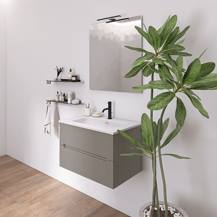 Questa composizione bagno cattura l'attenzione con il suo mobile sospeso con la finitura cannettata verticale che contraddistingue la serie Atena. Il top con lavabo integrato in ceramica bianca lucida si abbina a tutte le finiture e dona luminosità. Completano il look uno specchio rettangolare con lampada superiore a Led e due mensole a parete nere, creando un ambiente moderno, elegante e funzionale