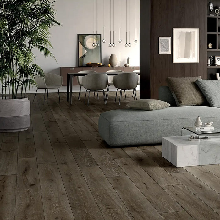 Salotto con pavimento in gres porcellanato effetto legno rovere della collezione Unica di Ceramiche Keope, formato 20x180, colore Brown