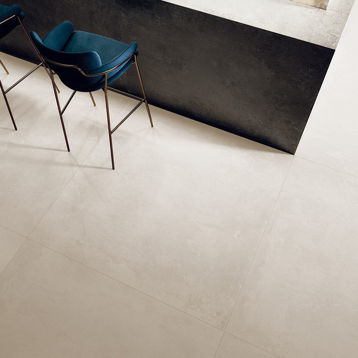 dettaglio penisola cucina con sgabelli in tessuto vellutato blu e rame, pavimento in gres porcellanato effetto cemento alla moda e di tendenza, design moderno urban style, della collezione ikon di ceramiche keope formato 120x120 colore White.