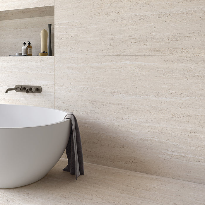 bagno moderno con pavimento e rivestimento in gres porcellanato effetto pietra naturale europea. Omnia di ceramiche keope 60x120 colore Tivoli Ivory