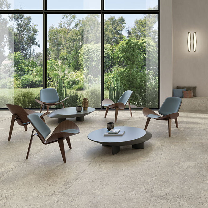 Lounge con tavolini moderni e sedie moderne, pavimento in gres porcellanato effetto pietra naturale europea. Omnia di ceramiche keope 120x120 colore Devix Grey