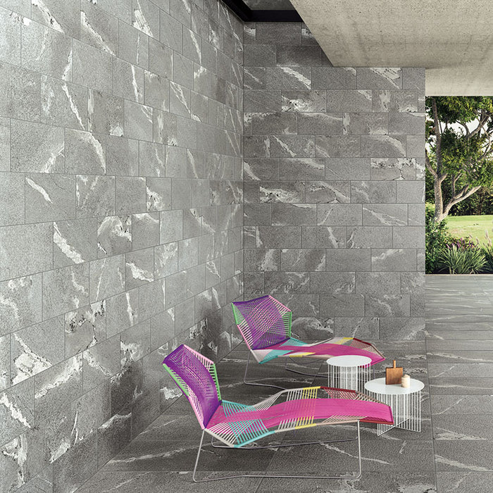 Muro con rivestimento in gres porcellanato effetto pietra. Percorsi Frame di ceramiche keope 30x60 colore Gneiss Grey