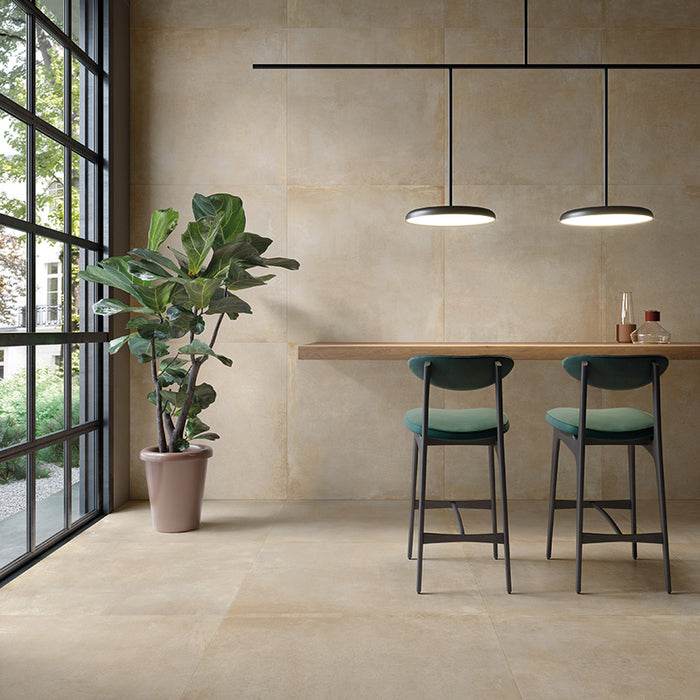 Dettaglio cucina con sgabelli verdi e pianta, pavimento e rivestimento in gres porcellanato effetto cemento industriale. Noord di ceramiche keope 80x80 colore Gold