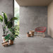 Dettaglio porticato con sedia e piante, pavimento e rivestimento in gres porcellanato effetto cemento industriale. Noord di ceramiche keope 80x80 colore Grey