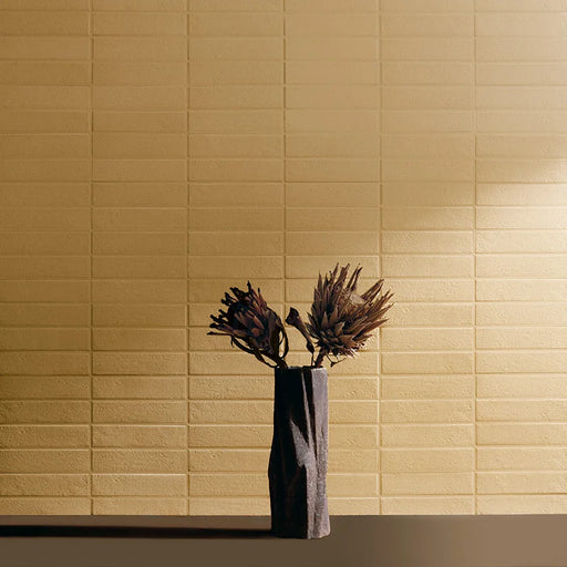 Dettaglio muro con rivestimento in gres porcellanato effetto materico e effetto mattoncino 4,5x18,6 cm, della collezione Koinè, colore Ocra, di Ceramica Settecento