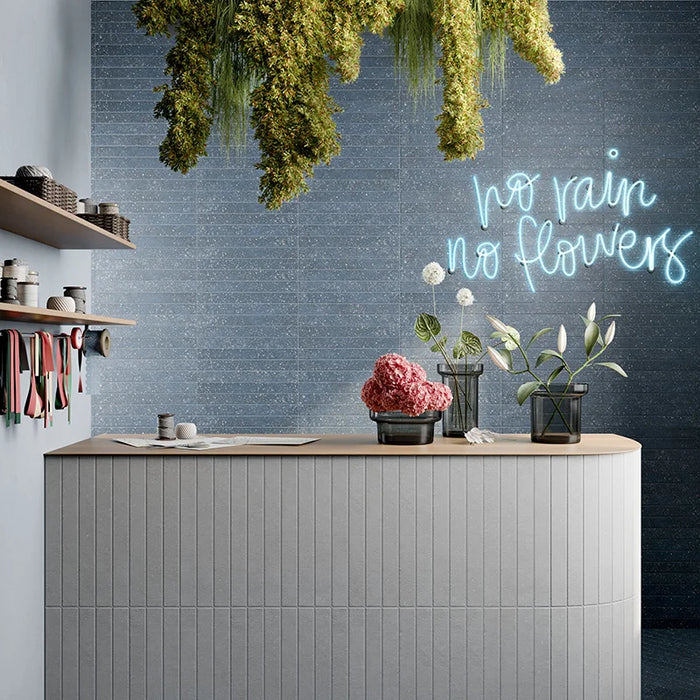Negozio moderno con rivestimento interno in gres porcellanato effetto mattoncino e graniglia della collezione Mixture di Ceramica Rondine, formato 4.8x45 cm, colore Royal Blue