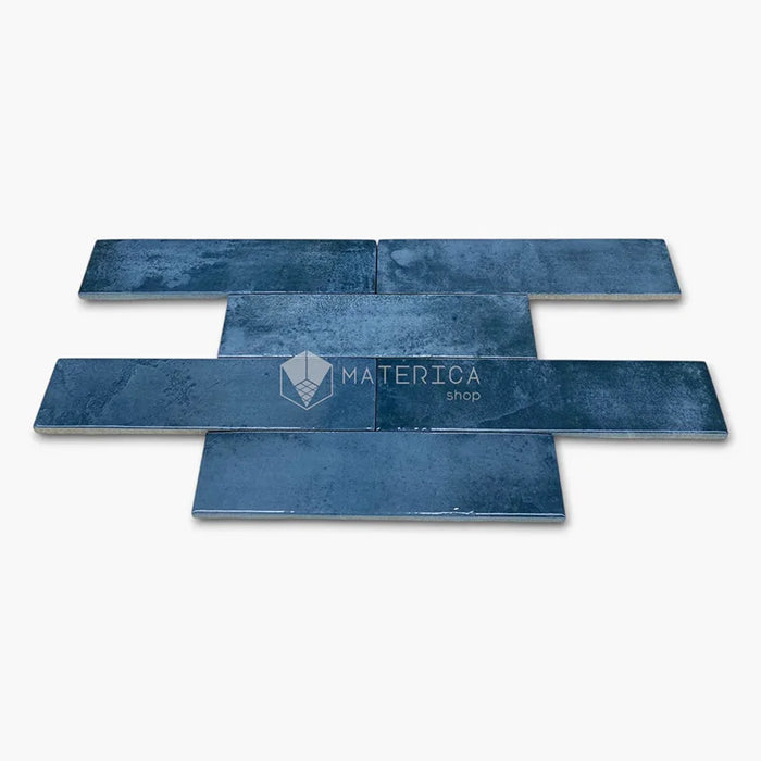 Rivestimento in gres porcellanato effetto mattoncino lucido 6x25 cm, collezione Mojave Blu di Ceramica Rondine. Piastrelle blu con posa a correre sfalsata per pareti di bagno e cucina.