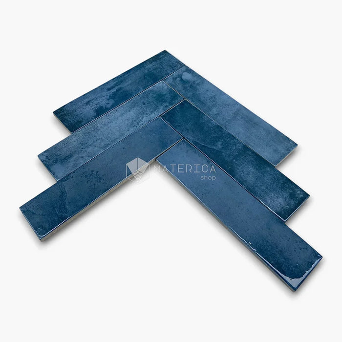 Rivestimento in gres porcellanato effetto mattoncino lucido 6x25 cm, collezione Mojave Blu di Ceramica Rondine. Piastrelle blu con posa a spina di pesce per pareti di bagno e cucina.